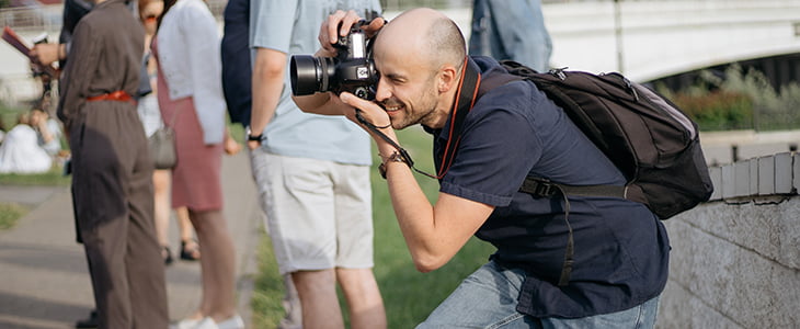 A member of a tour group crouches to take a photo