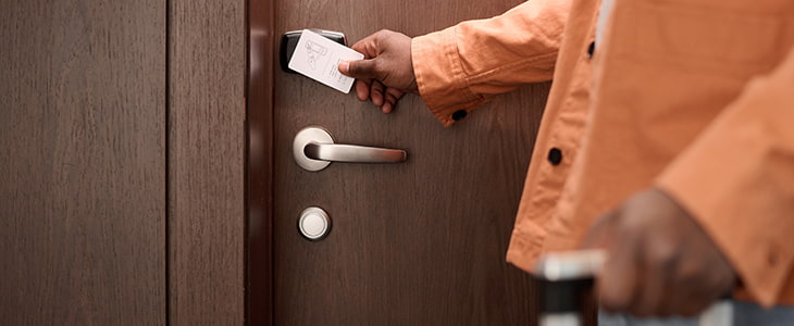 A hotel guest uses a keycard to access a hotel room