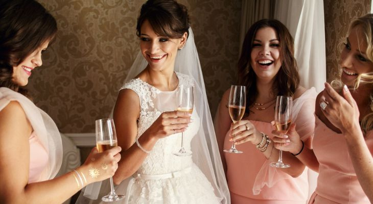 a bride and her bridesmaids share a champagne toast