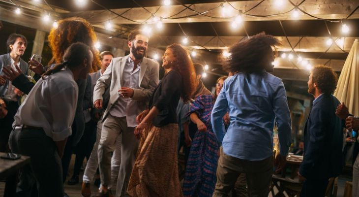 a group of guests dance at an engagement party