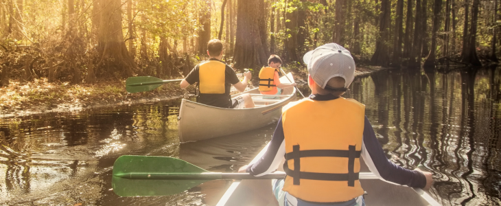 kids ride in canoes down a river