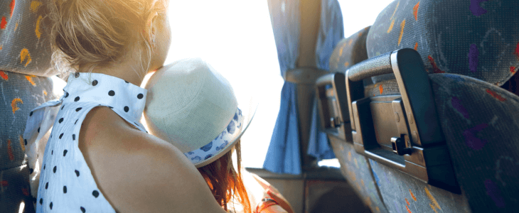 a woman and her child look out the window of a bus