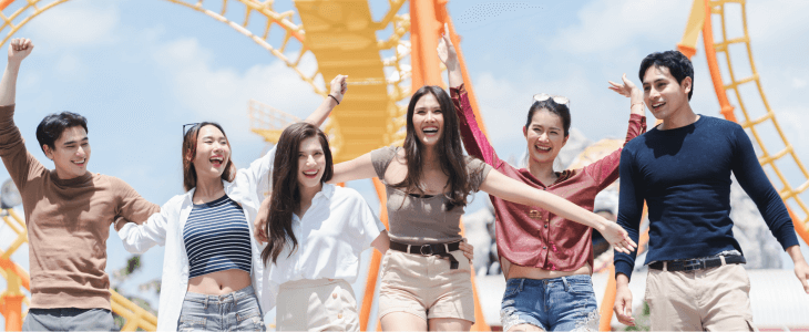 friends in front of a rollercoaster