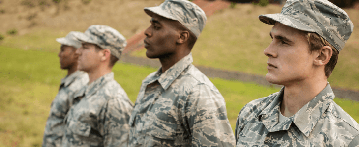 four military members stand at attention