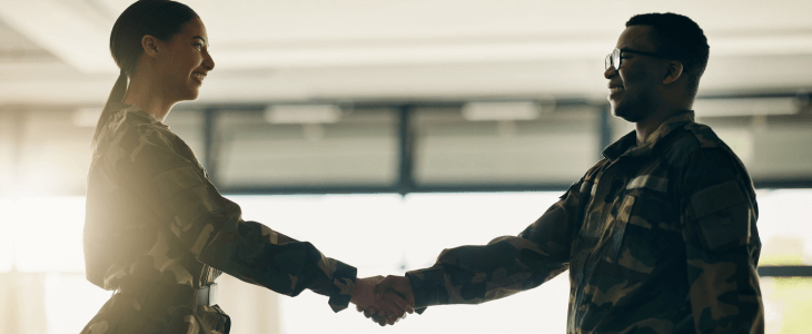 a military officer and a new recruit shake hands